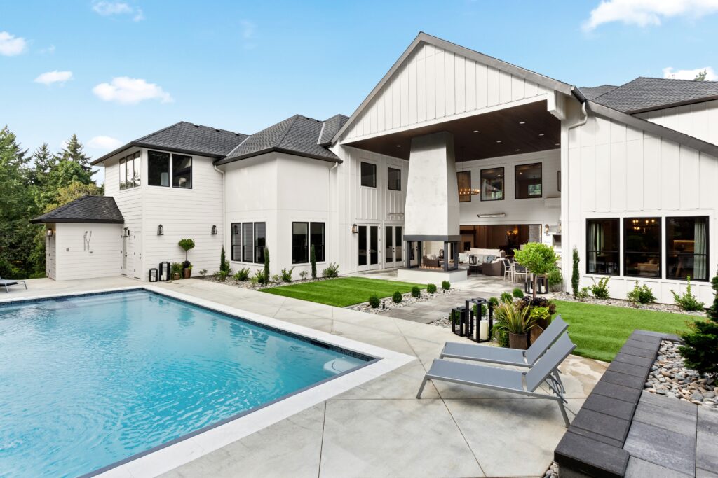 a custom luxury home built by C4 Builders, shown from the outside with a pool in the foreground